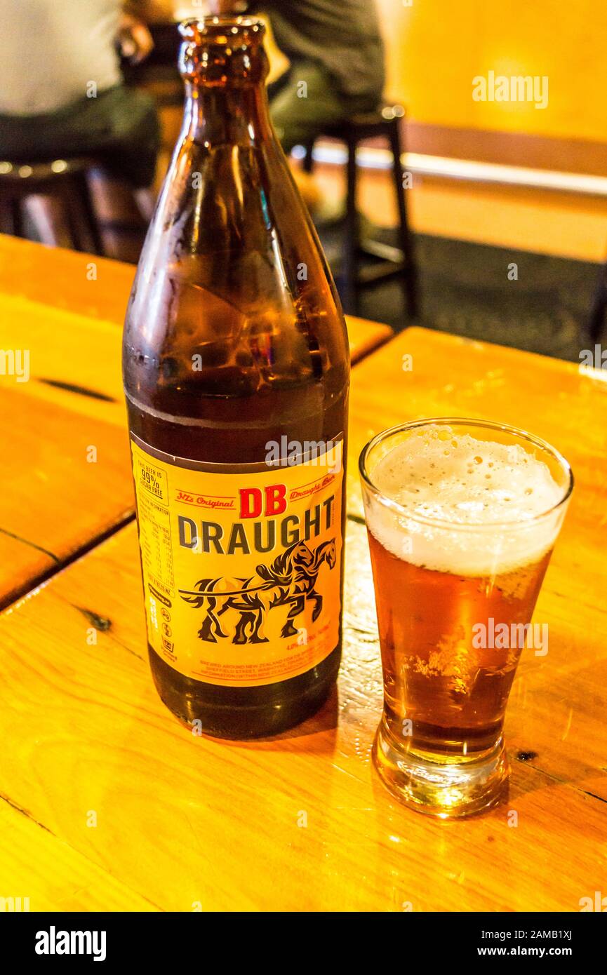 FOTOGRAFIEREN Sie Eine Flasche und ein halbes Pint Glas DB Draft Bier, Martinborough, Wairarapa, Neuseeland Stockfoto