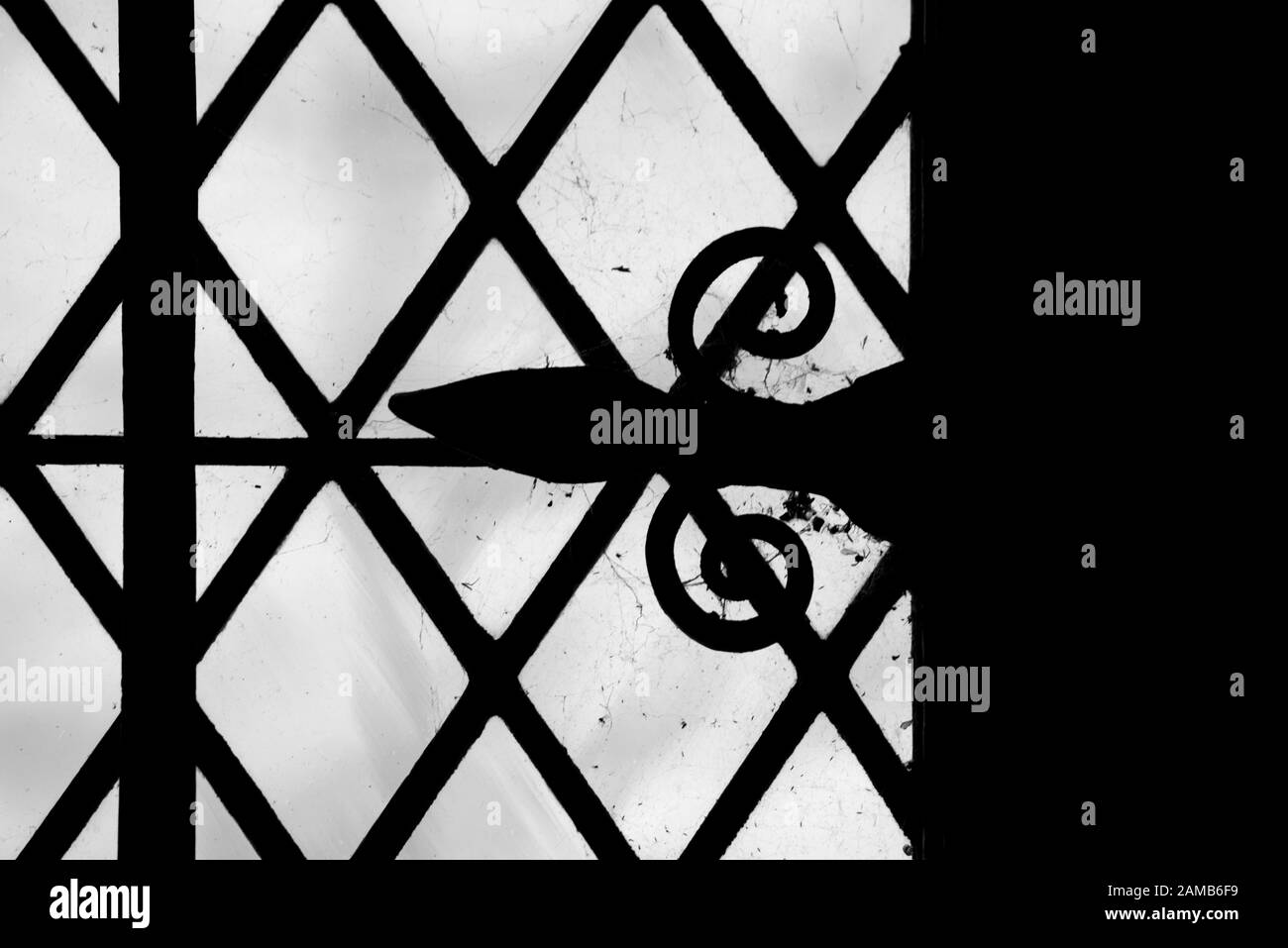 Kleines Fenster mit dekorativem Scharnier am Licht, das interessante Muster und Formen verleiht Stockfoto