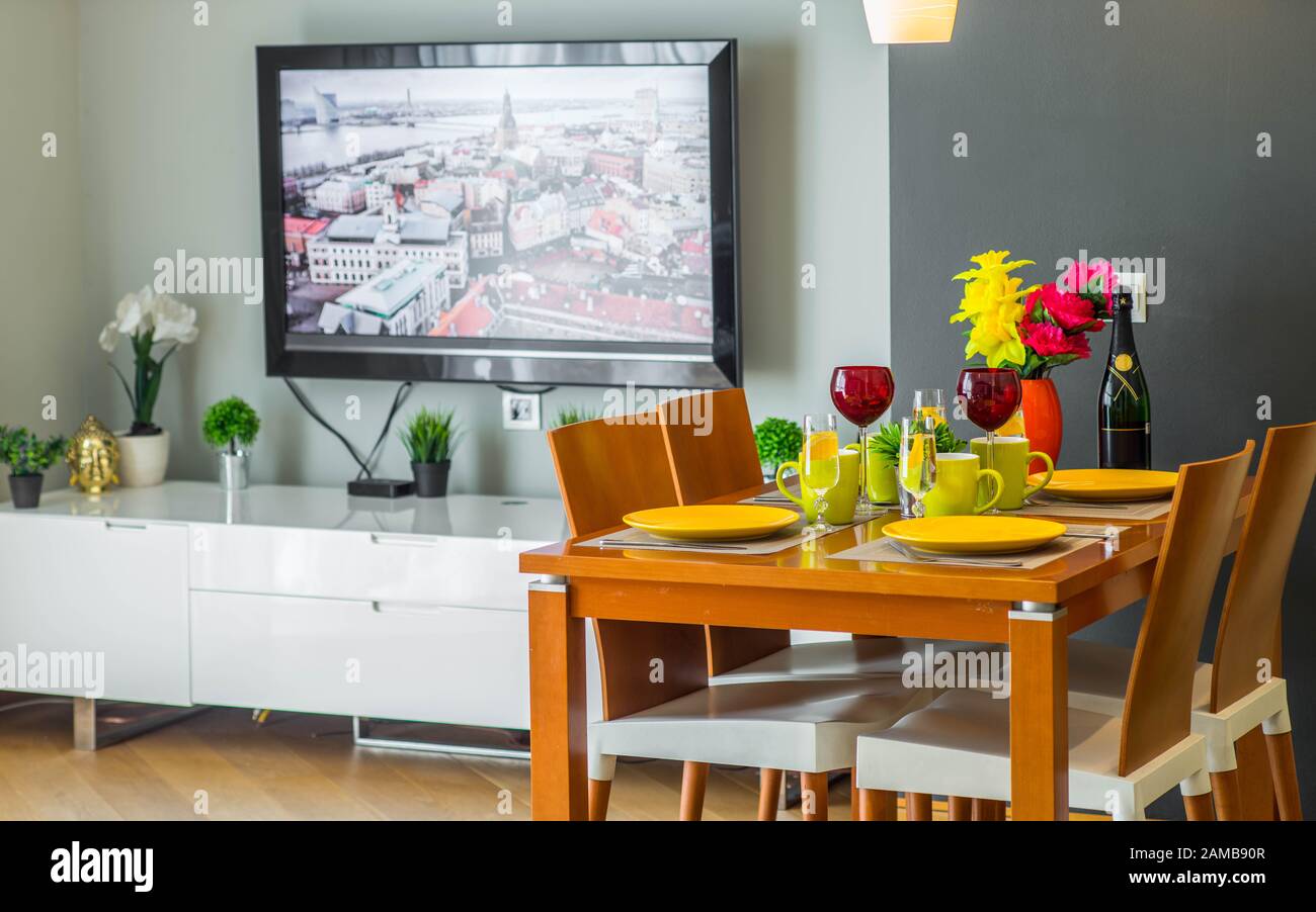 Nahaufnahme des verlegten Tisches. Modernes Wohnzimmer. Fernseher an der Wand. Stockfoto