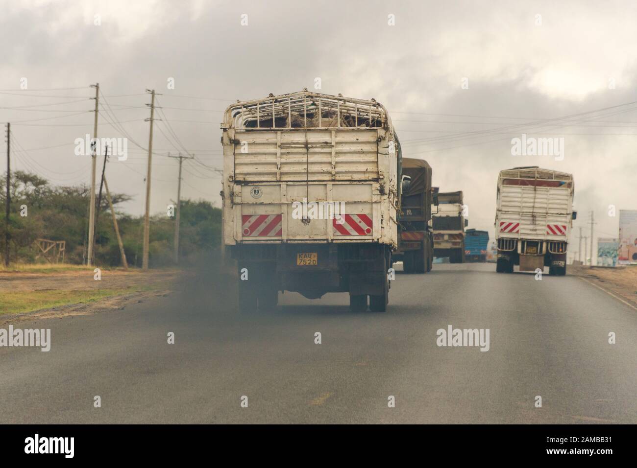 Ein LKW, der auf der Autobahn Mombasa unterwegs ist und Waren transportiert, die Abgase spucken, während er entlang fährt, Kenia Stockfoto