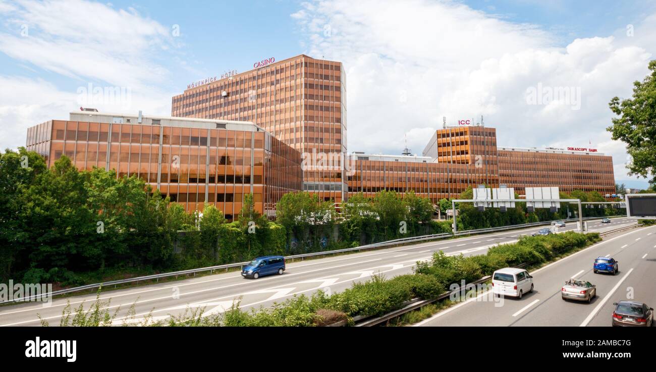Genf, SCHWEIZ - 10. JULI 2017: Panoramaaussicht auf die AUTOBAHN A1 und großes Bürogebäude mit mehreren Firmen, darunter Movenpick Hotel an Stockfoto