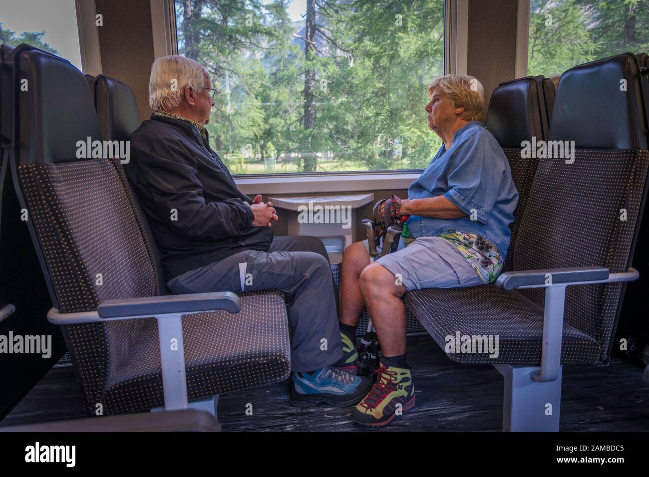 Ein Paar sitzt auf dem RhB-Zug, der von St. Moritz in der Schweiz nach Tirano in Italien fährt und den Bernina-Pass überquert. Stockfoto