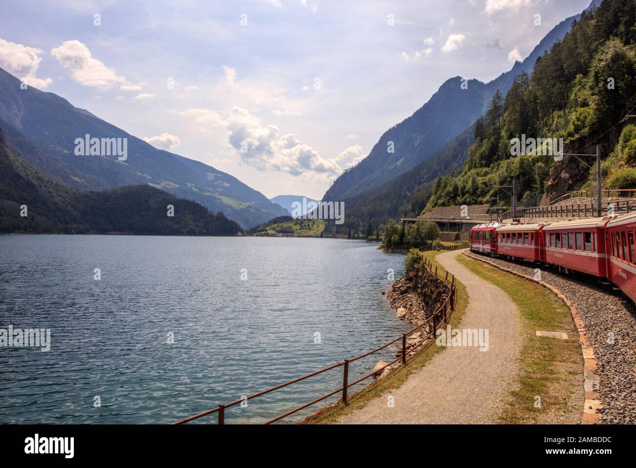 Ein Schweizer Zug fährt neben dem Poschiavo-See auf dem Weg nach Tirano in Italien Stockfoto