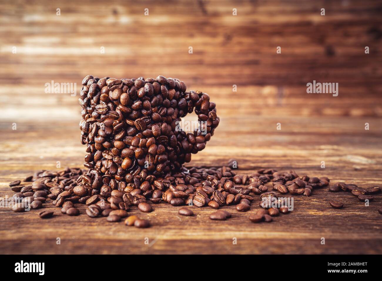 Eine Tasse mit vielen Kaffeebohnen, kräftiges Kaffeekonzept Stockfoto