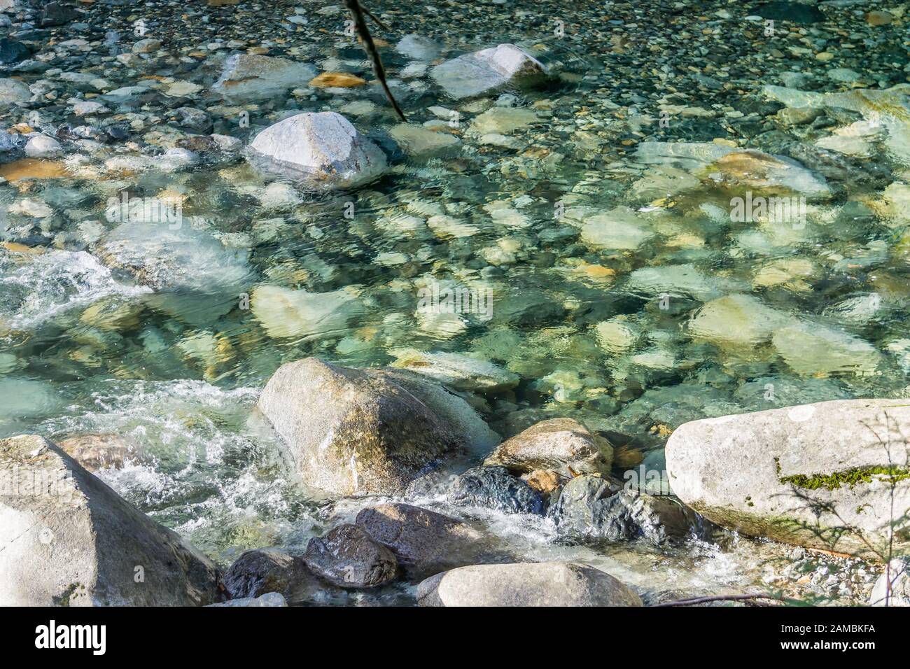 Klares Wasser fließt über Felsen im Denny Creek im Staat Washington. Stockfoto