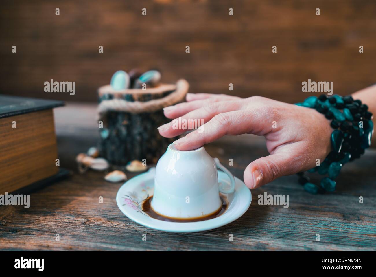 Frau toch den Becher, bevor sie mit der türkischen Kaffeetasse Glück erzählte Stockfoto