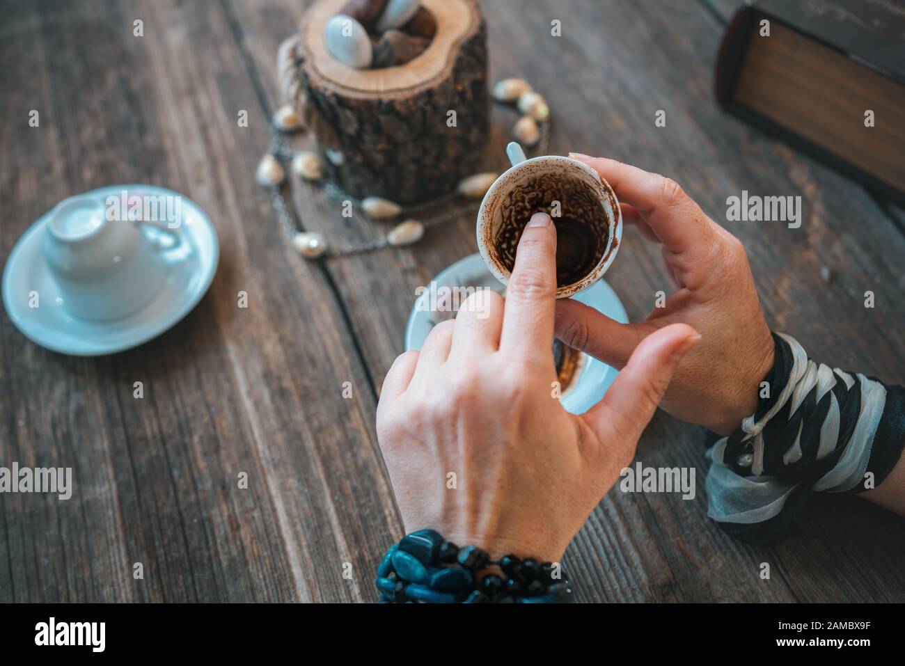 Frau hält den Becher und erzählt Glück mit traditioneller türkischer Kaffeetasse Stockfoto