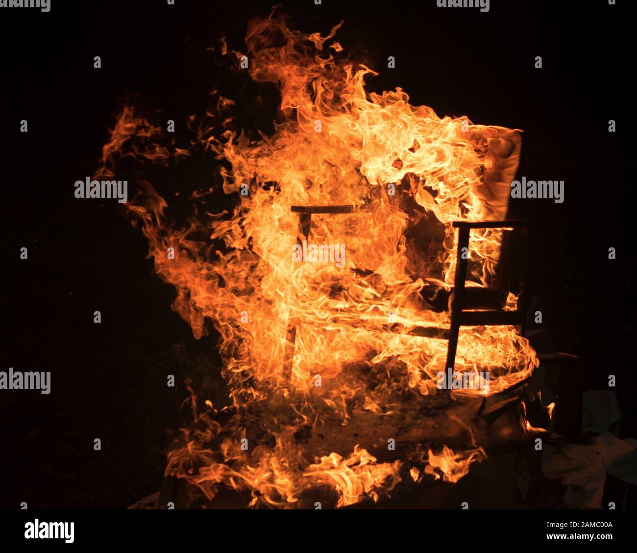 Holzstuhl verschlungen in Flammen Stockfoto