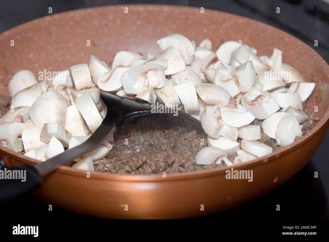 Gemahlenes Hackfleisch und Champignons in Bratpfanne Stockfoto