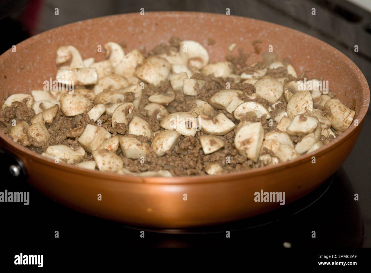 Gebräuntes Hackfleisch und Champignons in Bratpfanne kochen Stockfoto