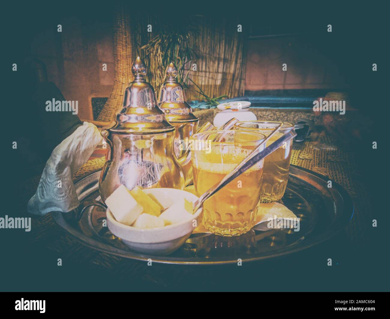 Vintage-Hintergrund mit frischem Minztee in typischen Tee-Metalltöpfen und -Gläsern in einem Restaurant in Marrakesch, Marokko. Es handelt sich um einen typischen Berbertee, der auch genannt wird Stockfoto