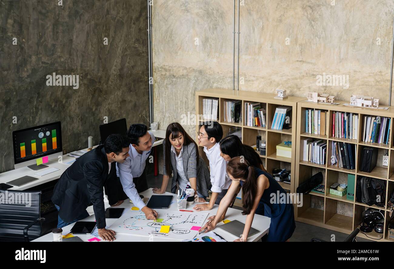Geschäftsleute treffen sich am kreativen Arbeitsplatz.Fröhliche Gruppe asiatischer Kreativteams Brainstorming Stockfoto