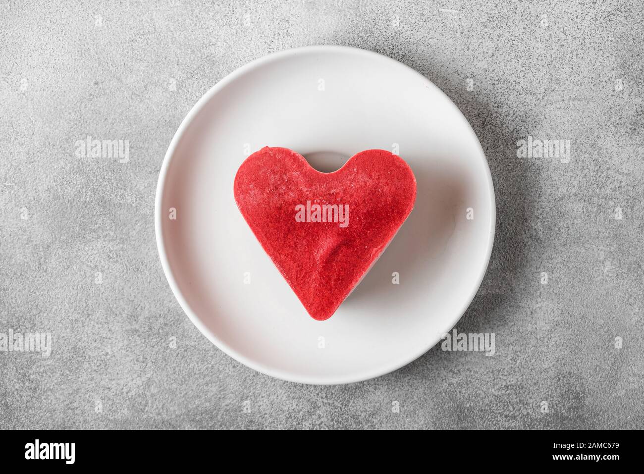 Valentins-Dessert. Herzförmige vegane Torte auf einem Teller. Gesundes köstliches Essen. Draufsicht. Liebeskonzept Stockfoto