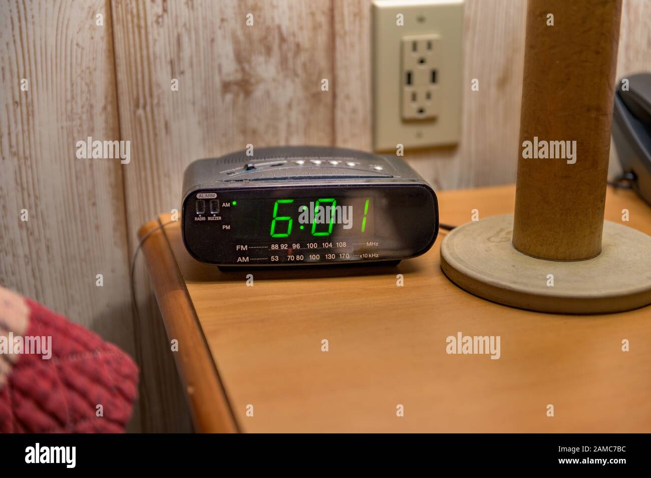 Nachttisch mit Tischleuchte, Wecker und Touchtone-Telefon Stockfoto