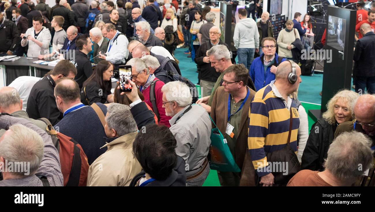 Gemischte Menschenmenge auf einer Fotohandausstellung im Innenbereich Stockfoto