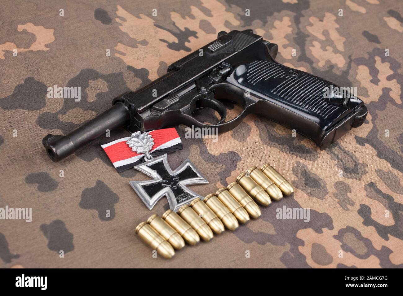 WWII ära Nazi-deutschen Armee 9 mm halbautomatische Pistole mit Iron Cross Award auf getarnte einheitlichen Hintergrund Stockfoto