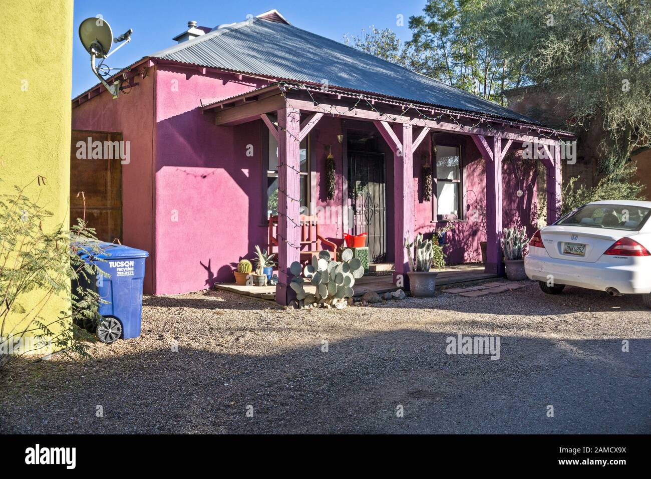 Hübsches Cottage im sanfteren Barrio Historic District Tucson mit neuem Wellblechdach auf Haus & Veranda und schockiertem rosa Stuck über alter Fassade Stockfoto