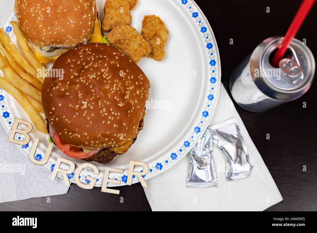 Leckere Burger mit Pommes auf einem weißen Teller. Wort Burger auf der Platte. Stockfoto