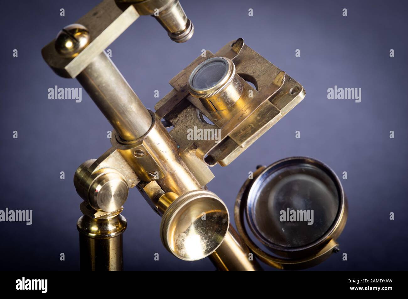 Nahaufnahme des alten Messingmikroskops vor grauem Hintergrund Stockfoto