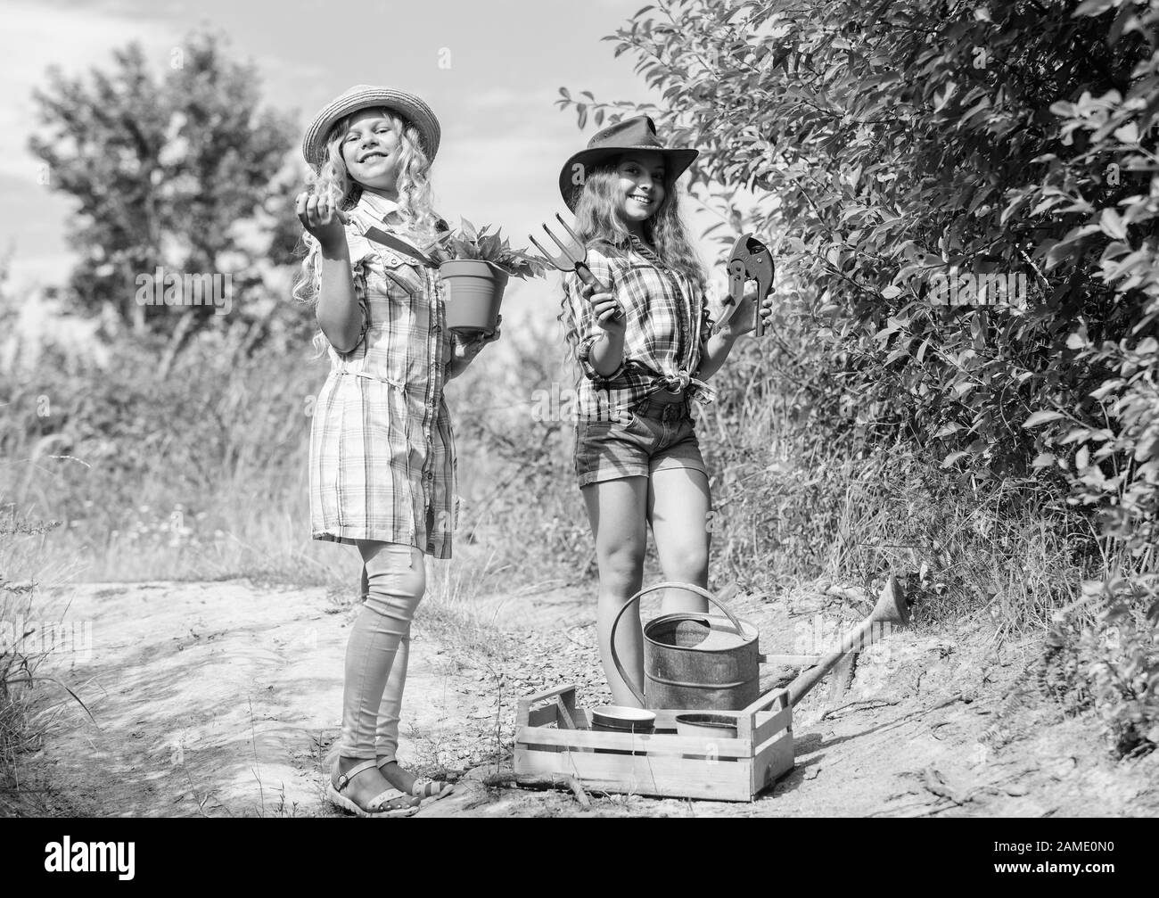 Ökologie und Umweltschutz. Landwirtschaft und Landwirtschaft. Feder Land. Kinder Gartengeräte halten. Tag der Erde. Sommer Familie Bauernhof. kleine Mädchen Bauer im Dorf. Im Blumenladen. Stockfoto