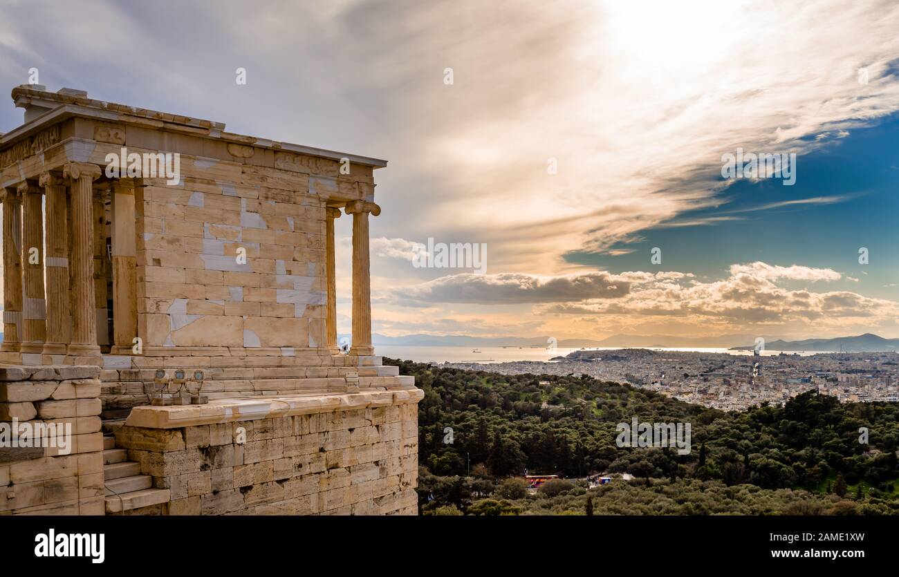 Der Tempel der Athena Nike auf der Akropolis von Athen, Griechenland, benannt nach der griechischen Göttin Athena. Philopappos Hügel und Piräus stehen im Hintergrund Stockfoto