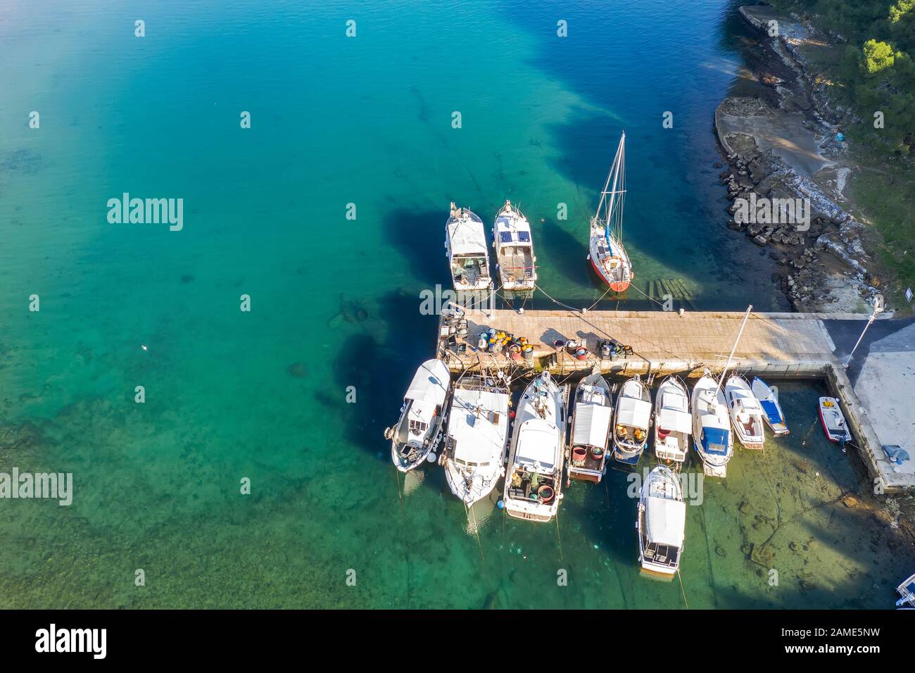 Luftaufnahme der Bucht von Runke mit kleinem Hafen und Pier mit Fischerbooten und Angelausrüstung in Premantura, Istrien, Kroatien Stockfoto