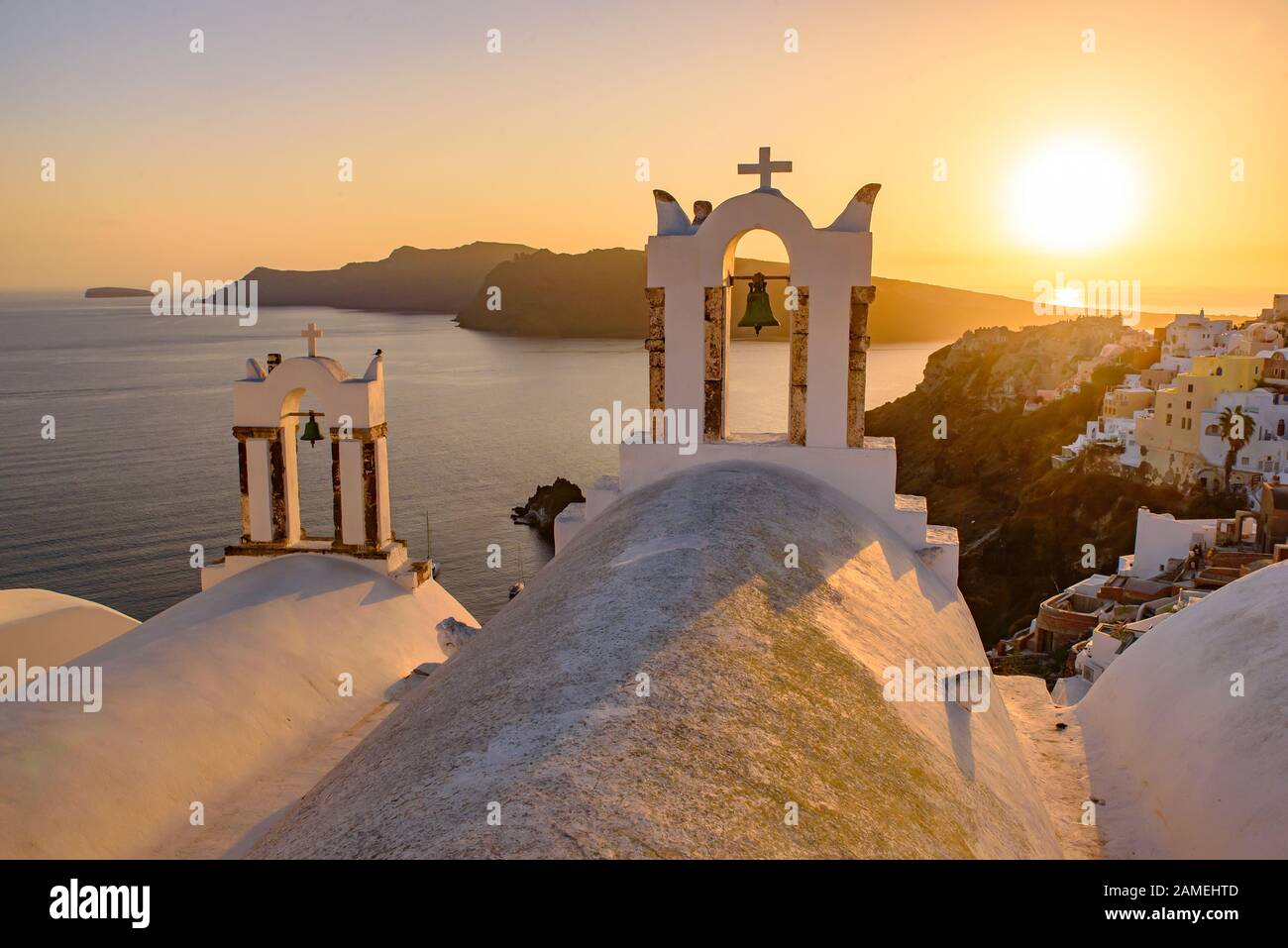 Kirchturm mit warmem Sonnenuntergang in Oia, Santorini, Griechenland Stockfoto
