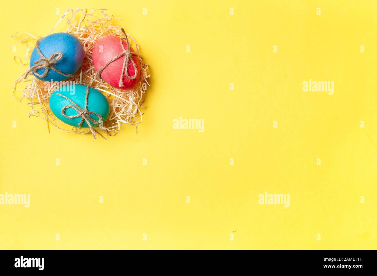 Osterkonzept. Bunte Eier auf hellgelbem Hintergrund mit Platz für Text. Draufsicht oder flache Lage Stockfoto