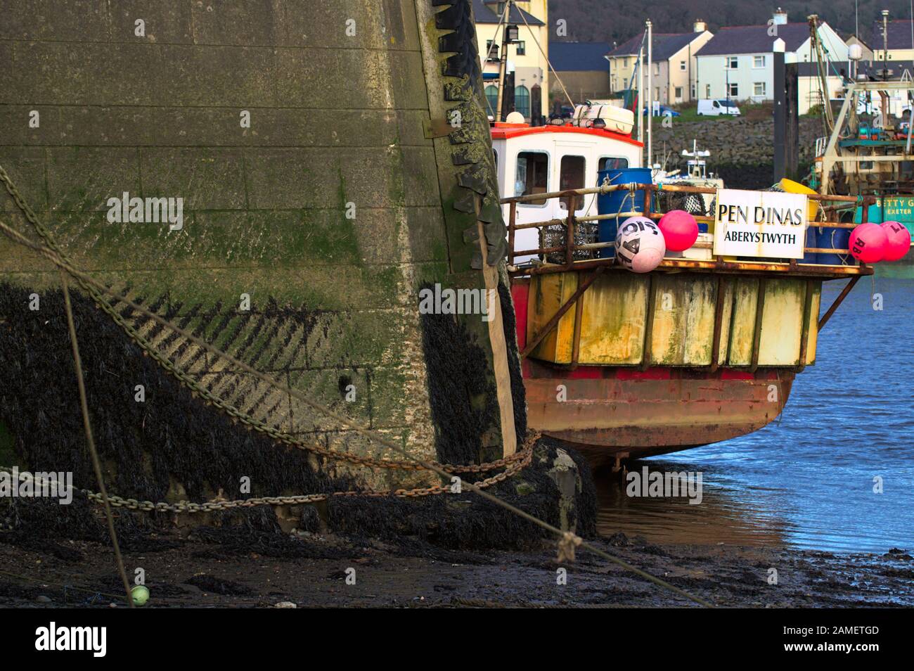 Aberystwyth UK Fischerboot "Pendinas" bei Ebbe neben der Hafenmauer festgemacht. Flecken in Algen durch Gezeitenfluss. Stockfoto