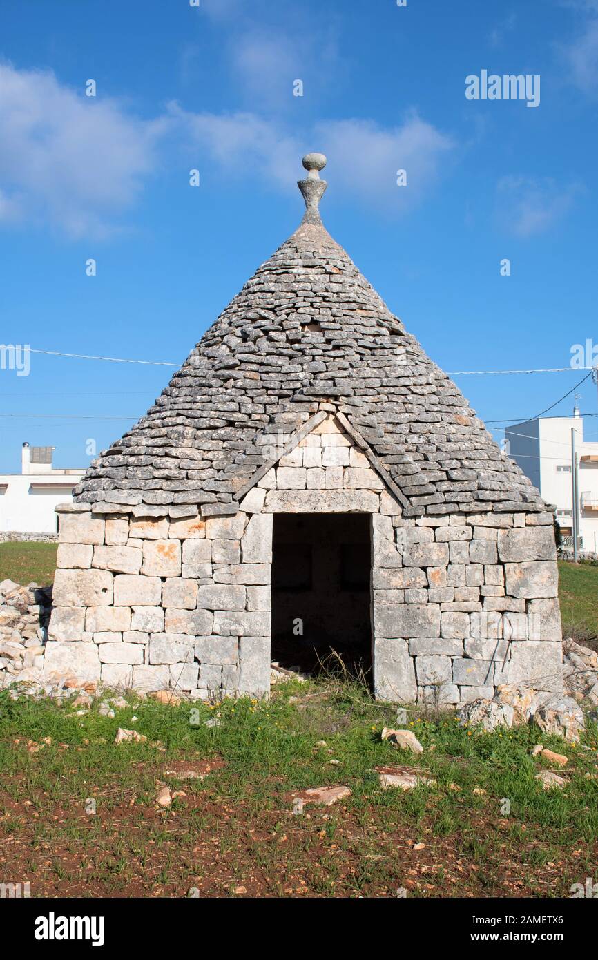 Trullo Haus mit Eingang, traditionelle alte Häuser und alte Steinmauer in Apulien, Italien, Europa, vertikal Stockfoto