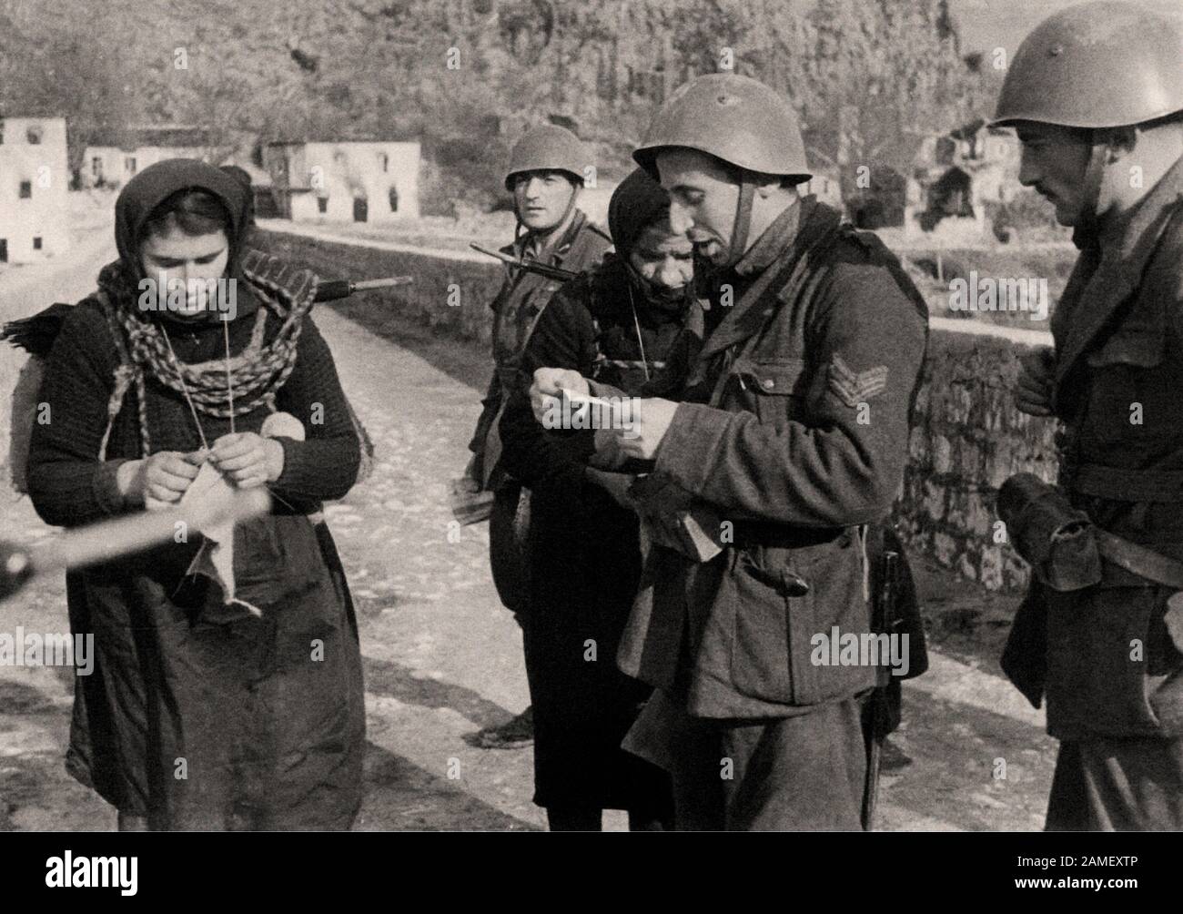 Italienisch im zweiten Weltkrieg Italienische Soldaten, die eine Brücke bewachen, überprüfen die I.D.s zweier montenegrinischer Frauen, Winter des Jahres 1942 Stockfoto