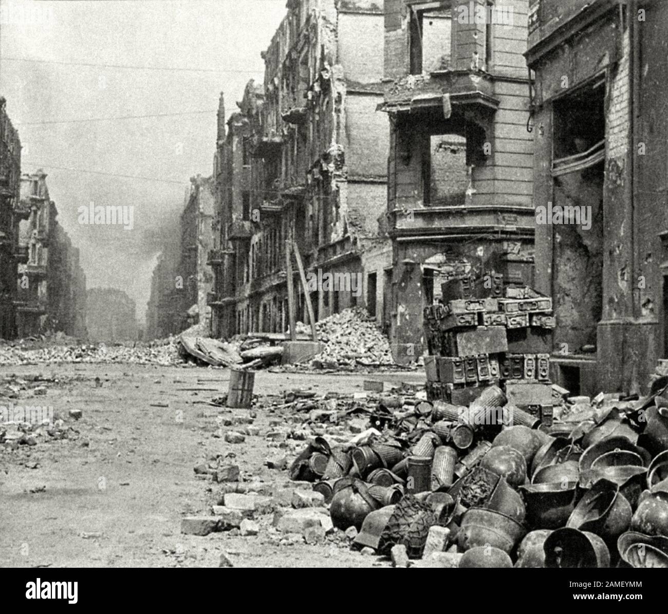 Wermuts Ausrüstung auf der Breslauer Straße, nachdem die NS-Garnisonen den Truppen der Roten Armee übergeben hatten: Deutsche Stahlhelme, Gasmasken, Munitionskästen. Stockfoto