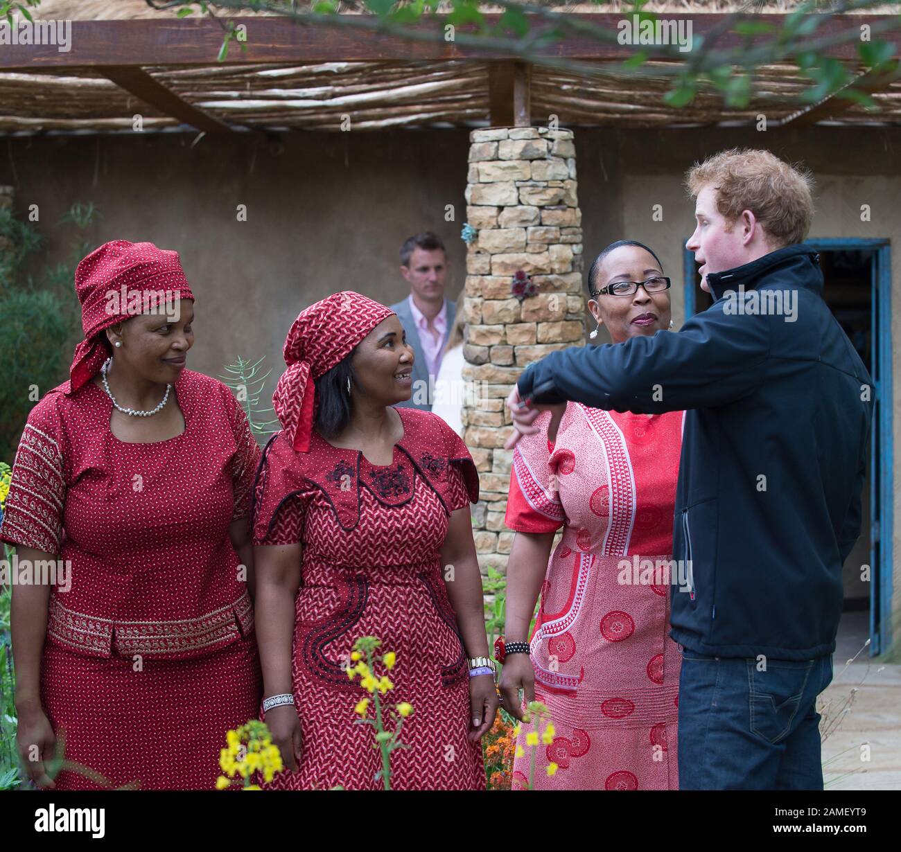 RHS Chelsea Flower Show, London, Großbritannien. Mai 2015. Prinz Harry, Herzog von Sussex chats zu Damen in afrikanischem Nationalkleid an der Sentebale Hope in Vulnerability Garden. Sie soll die Notlage von Lesothos verletzlichsten Kindern hervorheben. Sentebale ist eine Wohltätigkeitsorganisation, die von Prinz Harry und Prinz Seeiso gegründet wurde. Kredit: Maureen McLean/Alamy Stockfoto