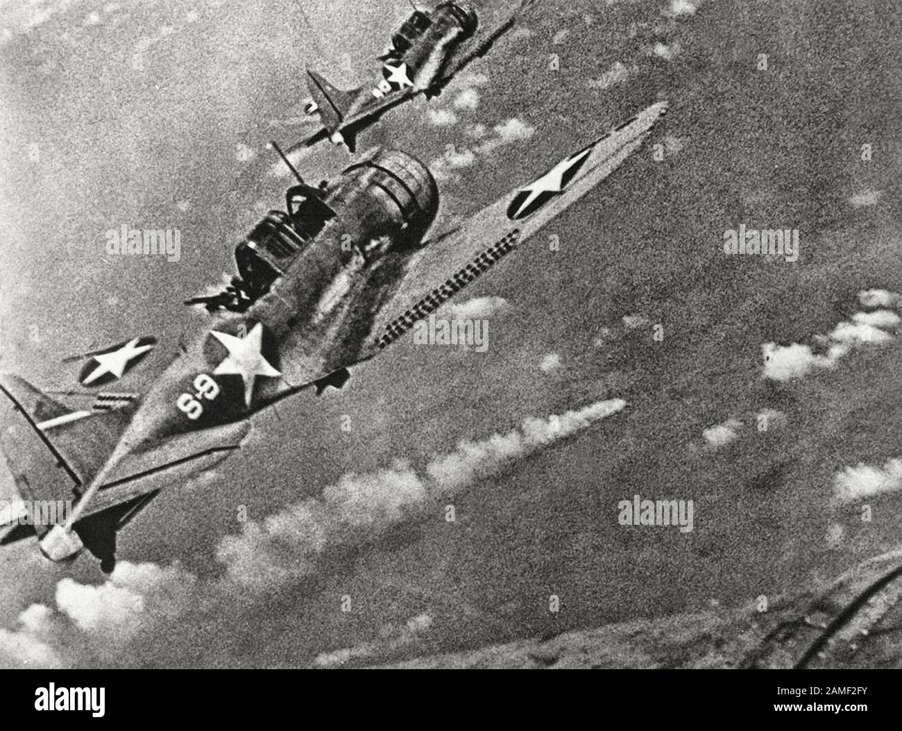 Amerikanische Kämpfer während des Angriffs auf die japanische Flotte vor Midway im Juni des Jahres 1942. Im Zentrum ist ein brennendes japanisches Schiff zu sehen. Das japanische airc Stockfoto