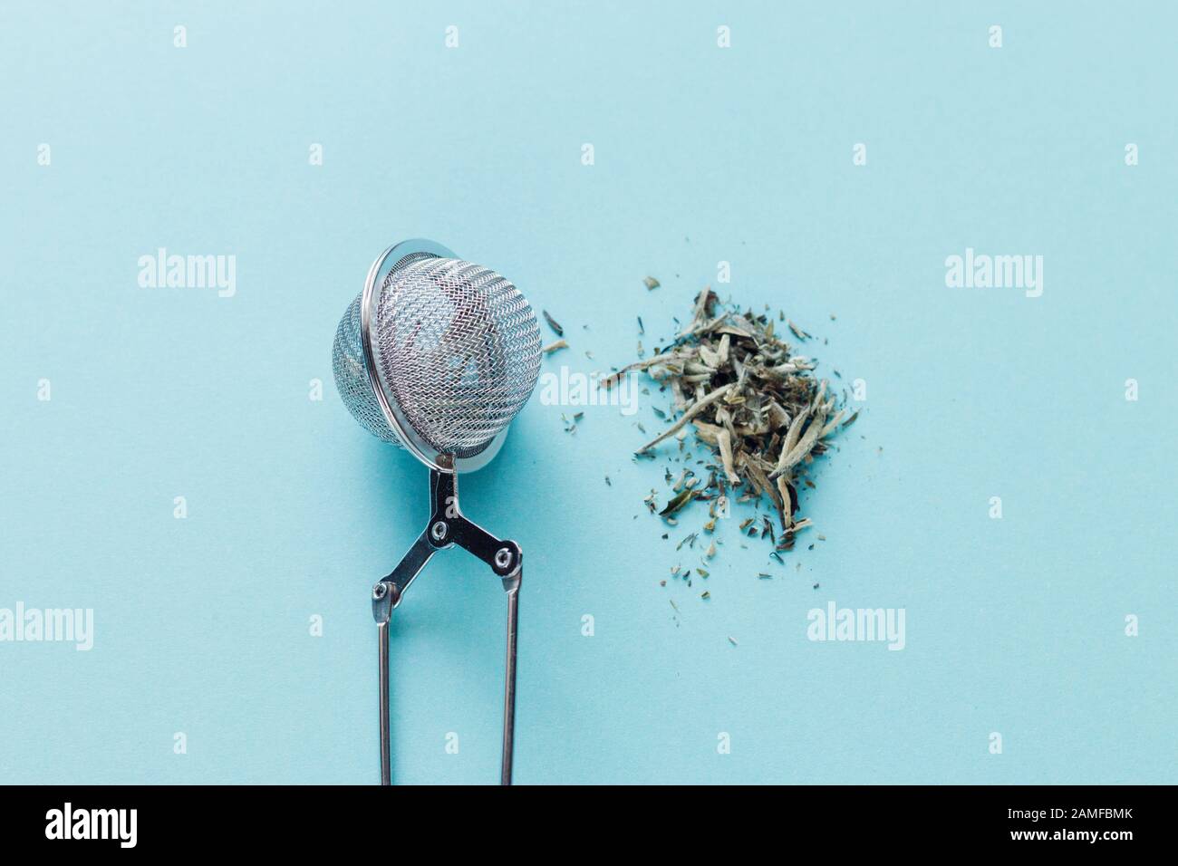 Blauer Hintergrund, Sieb und gegossen eine Handvoll Tee Bai Hao Yin Zhen Silver Nadeln, nützliche Eigenschaften von Tee, erhöht das Immunsystem und stellt e zur Verfügung Stockfoto