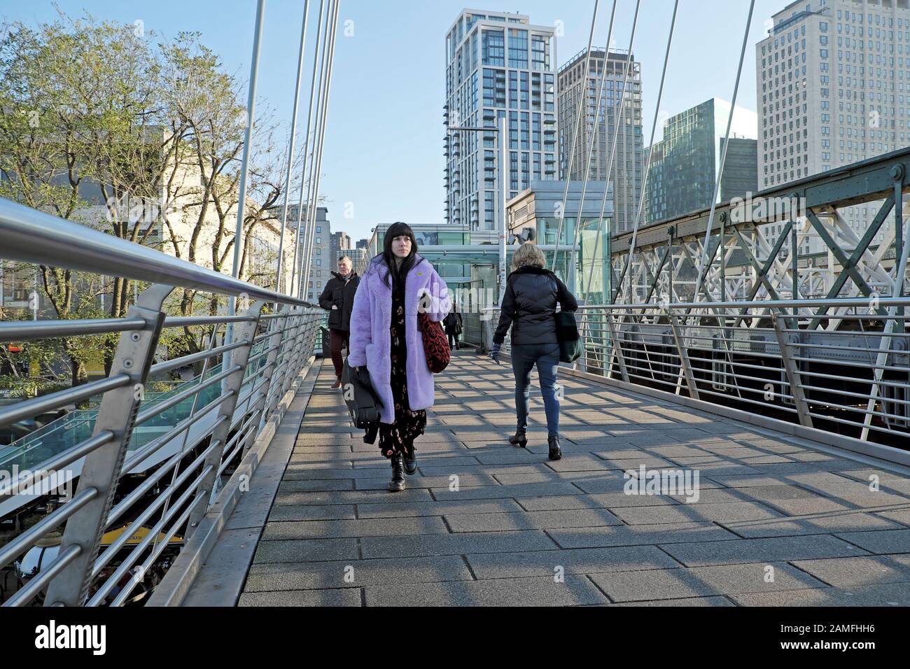 London Street Fashion Woman mit lilafarbenem Kunstfellmantel, der im Winter auf der Waterloo-Fußgängerbrücke in England, Großbritannien, SPAZIEREN GING KATHY DEWITT Stockfoto