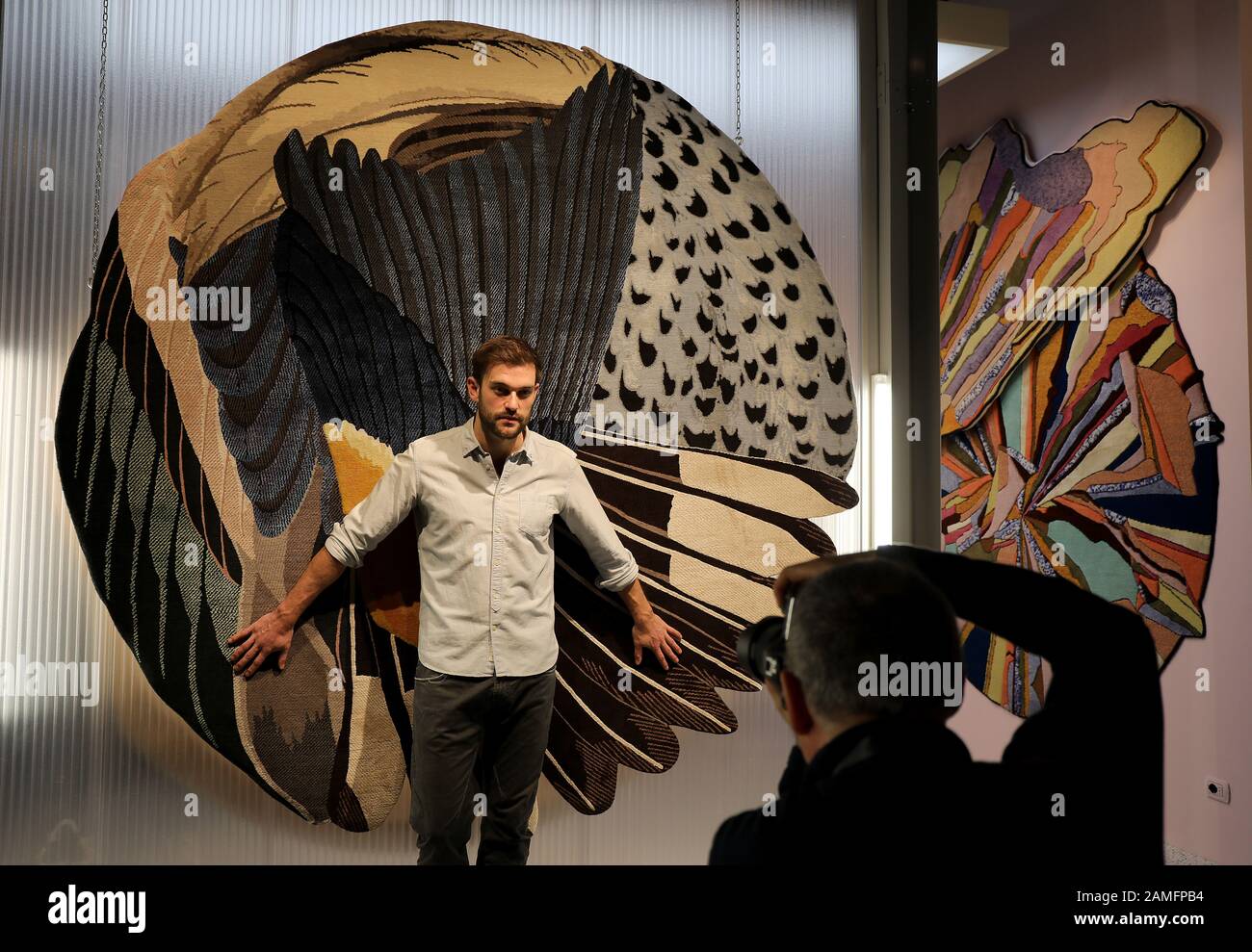 Köln, Deutschland. Januar 2020. Kilian steht vor einem Wandteppich am Stand des Herstellers CC-Tapis/Mazalli. Die Möbelmesse findet vom 13. Bis 19.01.2020 in Köln statt. Credit: Oliver Berg / dpa / Alamy Live News Stockfoto