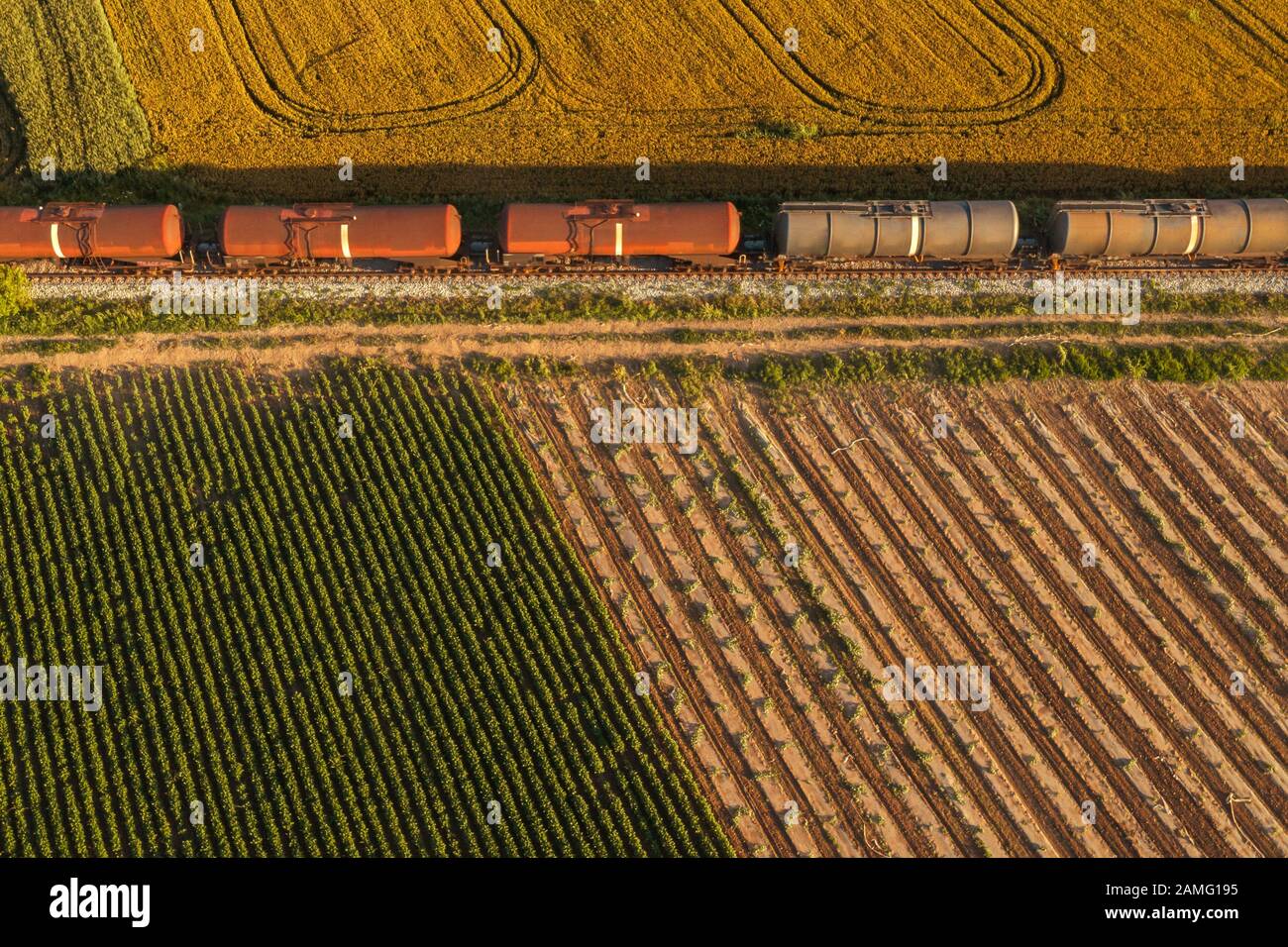 Schienengüterverkehr, Luftaufnahme von Zug passiert auf Bahnhöfen durch Feldern in Landschaft Stockfoto