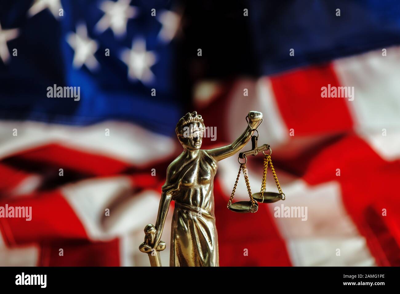 Recht und Gerechtigkeit in den Vereinigten Staaten von Amerika, Statue von Lady Gerechtigkeit mit USA-Flagge im Hintergrund, selektiver Fokus Stockfoto