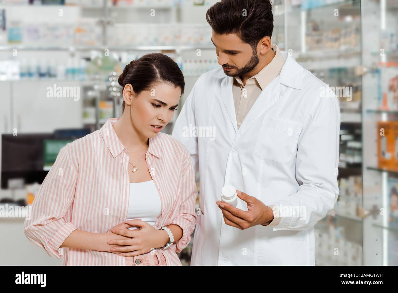 Apotheker, der Kunden mit Magenerkrankung in Drogerien Pillen zeigt Stockfoto