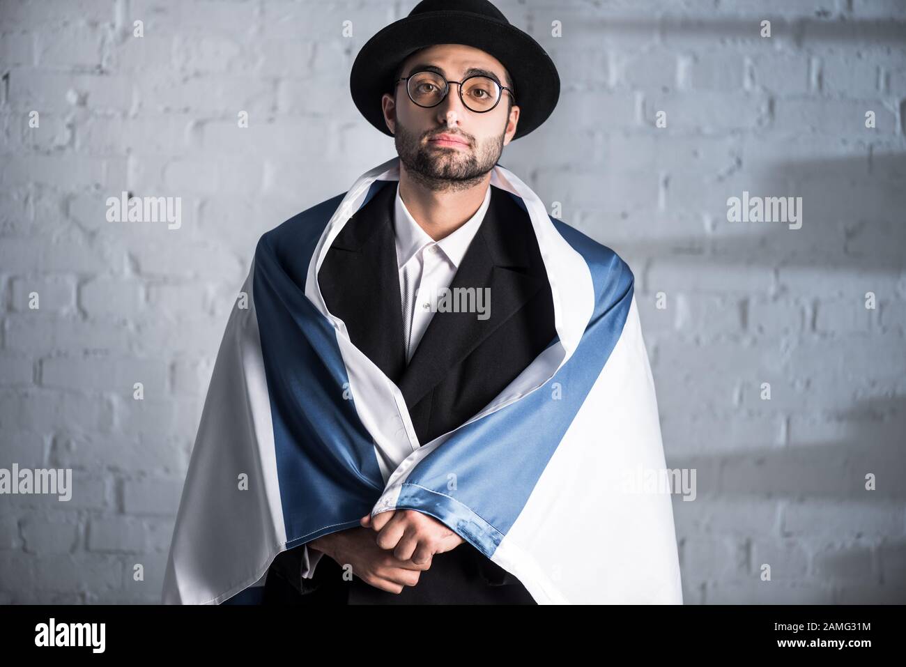 Gutaussehender jüdischer Mann in Brille, die die Flagge israels hält Stockfoto