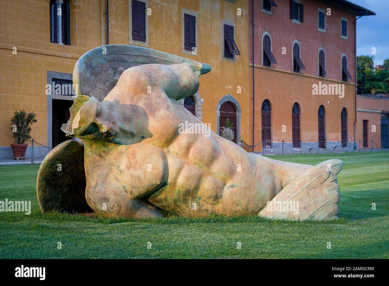 Skulptur eines gefallenen Engels im Zentrum von Pisa. Nahansicht, grünes Gras und Sonnenuntergang. Poscana, Pisa. Stockfoto