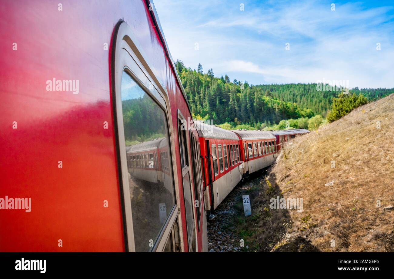 Roter Retro-Zug in den Bergen Bulgariens, Alpenbahn auf dem Balkan Stockfoto