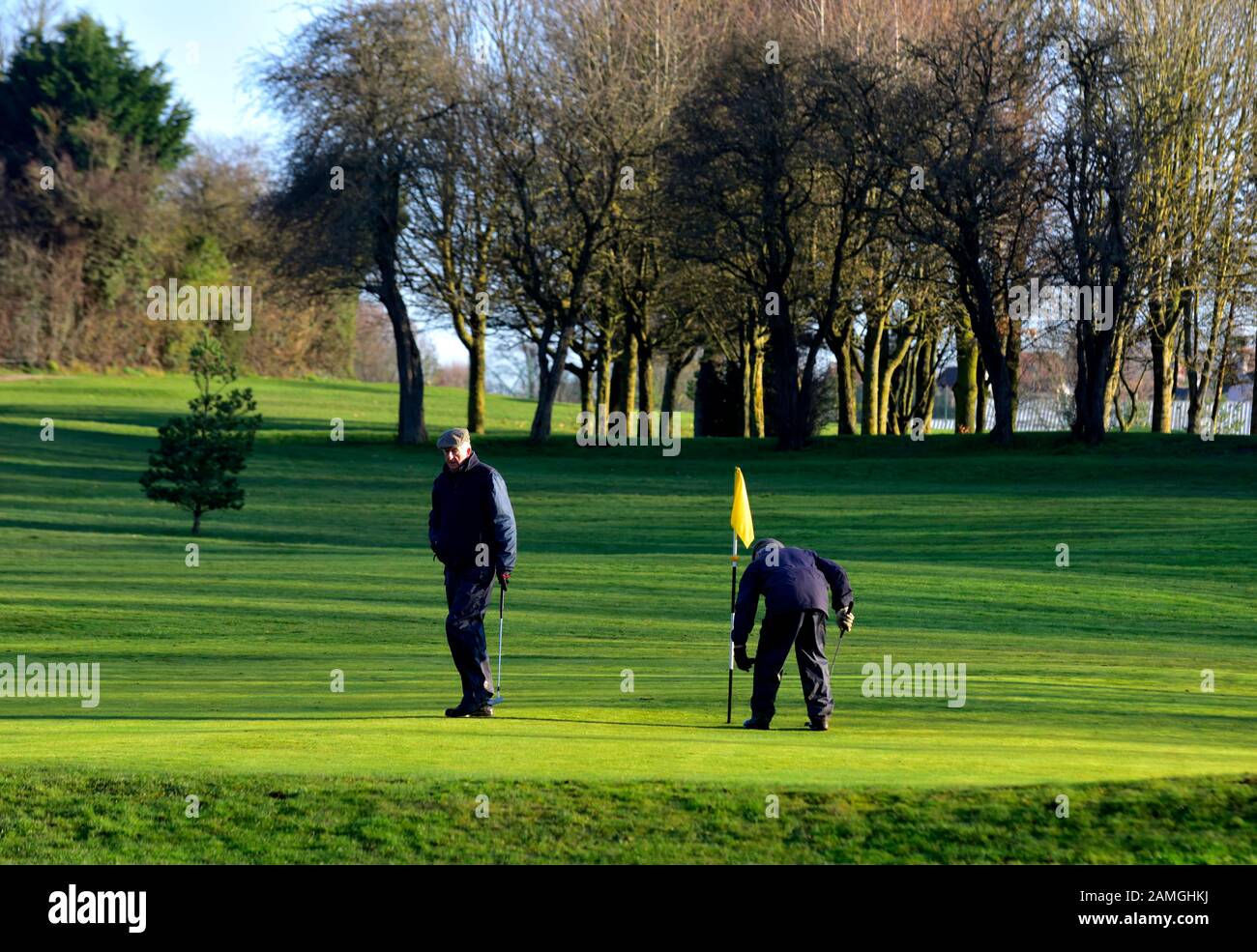 Zwei Rentner, die an einem sonnigen Wintermorgen Golf spielen, West hallam, Ilkeston, Nottingham, England, Großbritannien Stockfoto