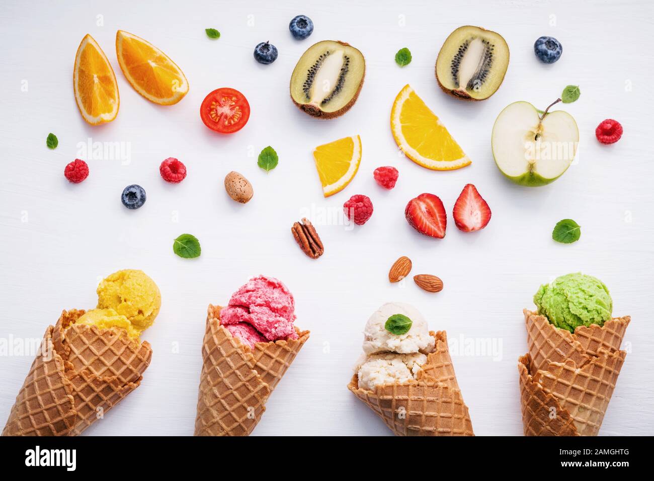Set von Eisschaufeln in verschiedenen Farben und Geschmacksrichtungen mit Beeren, Nüssen und Früchten Dekoration isoliert auf weißem Hintergrund Stockfoto