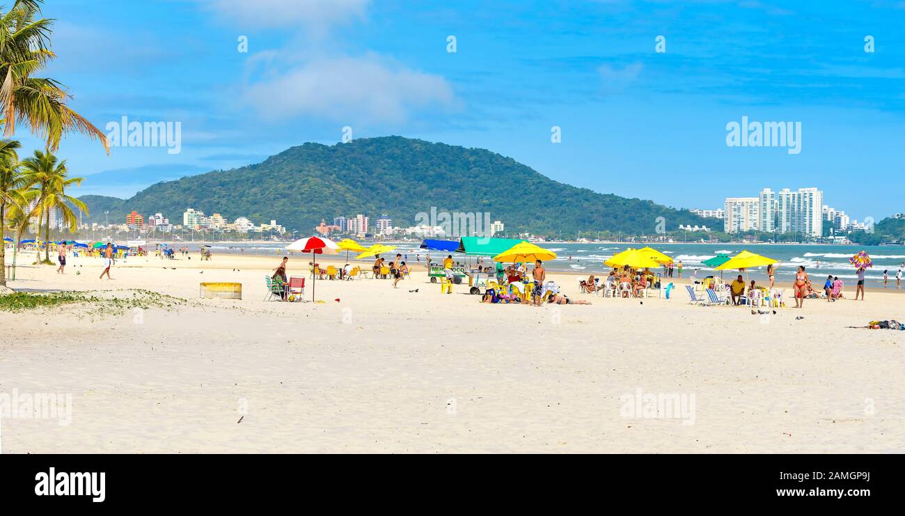 Guaruja - SP, Brasilien - 19. November 2019: Menschen am Strand, die einen sonnigen Tag am Sand und am Meer genießen. Brasilianische Touristendestination. Panorama V Stockfoto