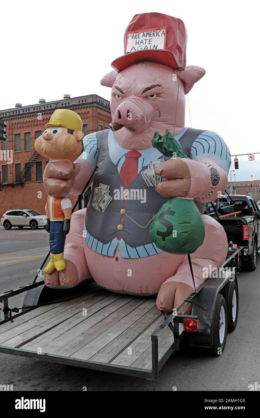 "Make America Hate Again", ein Monikor auf dem Trump-Slogan, steht auf dem Hut eines Schweins, das einen Arbeiter in der einen Hand zusammendrückt und Geld in der anderen hält." Stockfoto