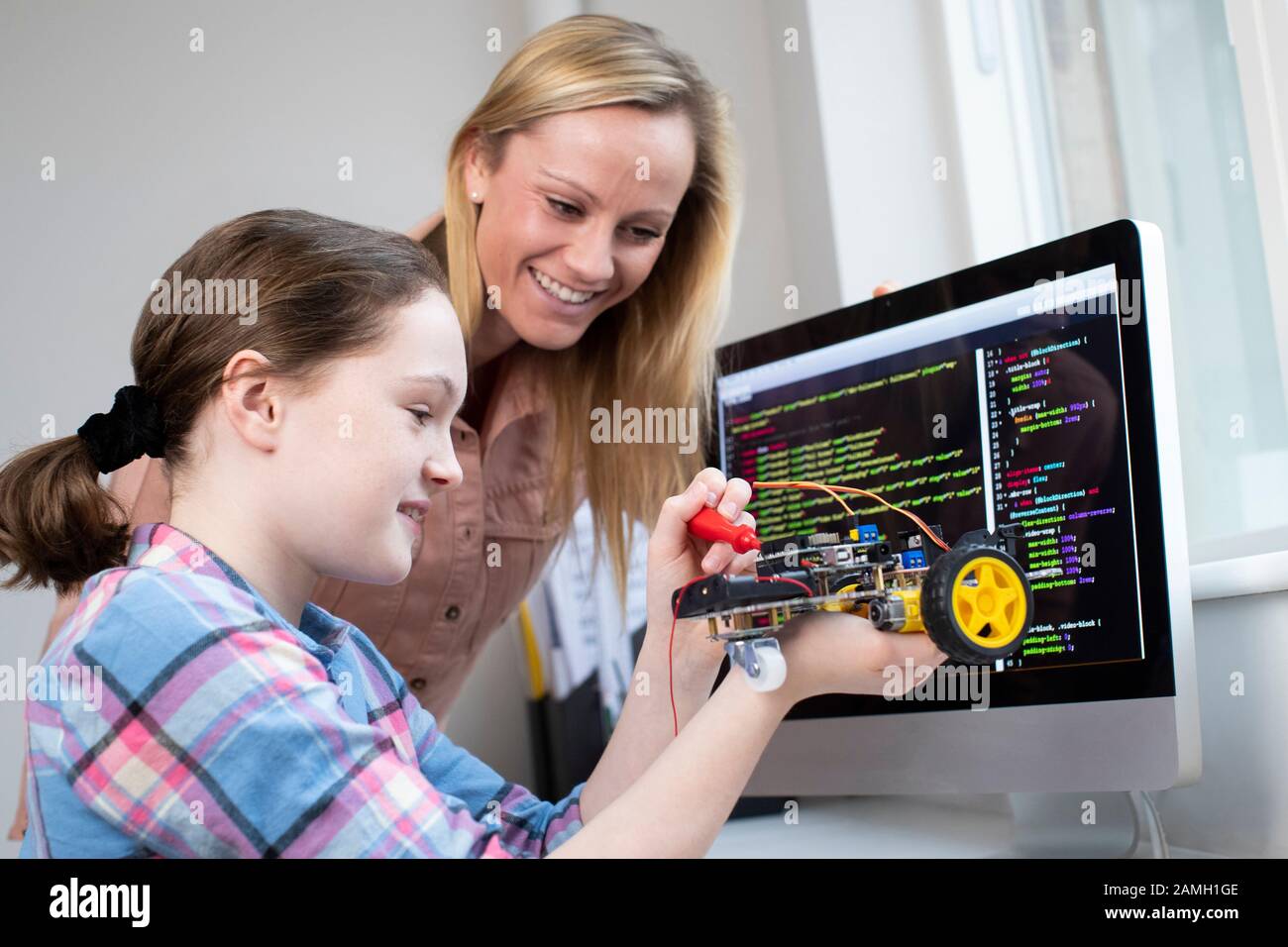 Lehrer Hilft Weiblichen Schülern Beim Bau Von Roboterwagen In Der Lektion "Wissenschaft" Stockfoto