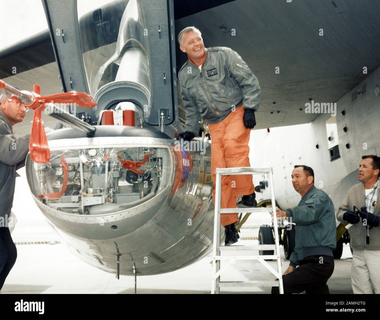 Foto des NASA-Forschungspiloten Milt Thompson, der auf einer Leiter steht und in das Cockpit des M2-F2-Hubkörperforschungsflugzeugs am NASA Flight Research Center (heute Armstrong Flight Research Center), Edwards Air Force Base, Kalifornien, USA, Februar 1966 einsteigt. Mit freundlicher Genehmigung der NASA. () Stockfoto