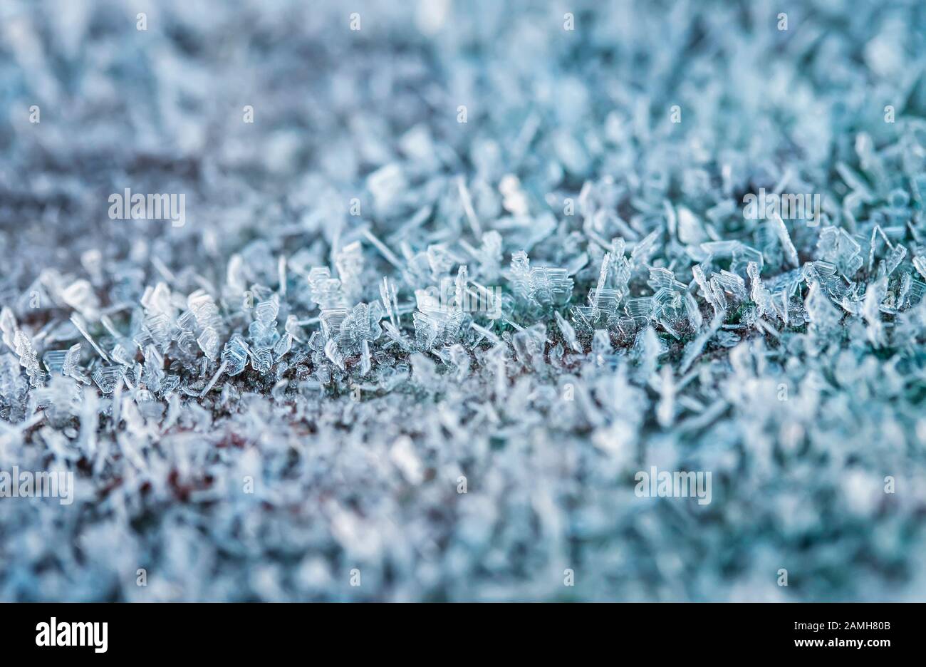 Festlicher Neujahrshintergrund mit glänzenden transparenten Texturkristallen aus kaltem Frost und Schnee bedecken die Oberfläche im Winter frostig Morgen Stockfoto